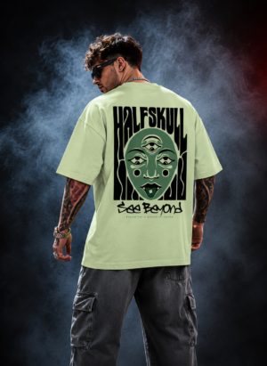 Man wearing the pastel green Half Skull Beyond Vision oversized T-shirt with the many eyed face and See Beyond back print