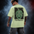 Man wearing the pastel green Half Skull Beyond Vision oversized T-shirt with the many eyed face and See Beyond back print